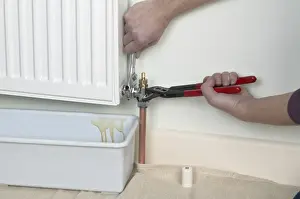 Dripping Prints: Unlock the bleed valve on a radiator, container underneath radiator