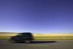 Images Dated 26th June 2006: USA, Montana, SUV on highway beside wheatfield (blurred motion)