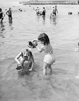 Sunshine Prints: USA, New York City, Coney Island, Girls (6-7, 8-9) playing in water