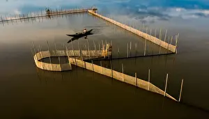 Vietnam - Fisherman go fishing on boat near net system on Tam Giang lagoon, Hue, Thua Thien Hue