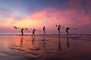Images Dated 23rd August 2015: Vietnam - Fishermen going with stilts, hanging fishing tools on the beach, in sunrise