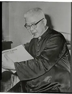 Vietnamese Archbishop Reading with Cigar in Mouth