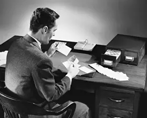 50 59 Years Prints: Back view of man sitting and looking at address cards