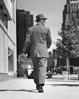 Dedication Gallery: Back view of man walking on street