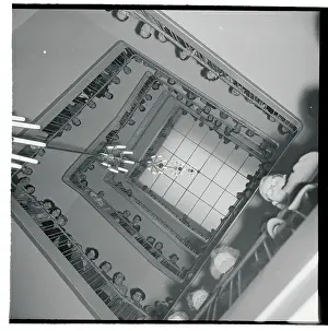 View of People Peering Down Open Stairwell