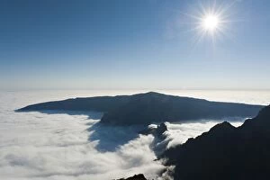 View from the summit, bright sun, Piton des Neiges Mountain, 3069 m, above the clouds, near Cilaos