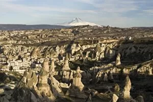 The village of Goreme in front of the snow-capped volcano Erciyes Dagi, Cappadocia, Turkey