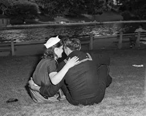 Vintage photograph of sailor and his girlfriend sitting together on grass