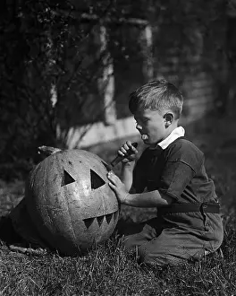 Crouching Prints: Vintage photograph showing, Boy (8-9) Carving Jack-O-lantern