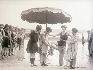 Vintage photograph showing young woman undressing on beach