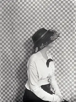 Delicate Prints: Vintage photograph of young trendy woman sitting against checked curtain