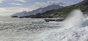 Images Dated 7th September 2012: Waves breaking on the rocky coast, cottages and rugged mountains at the back, Flakstad, Lofoten