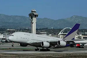 Wide body airliner taking off at Los Angeles International Airport (LAX) with control tower in background