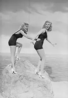Wilde Twins Posing atop a Rock in Swimsuits