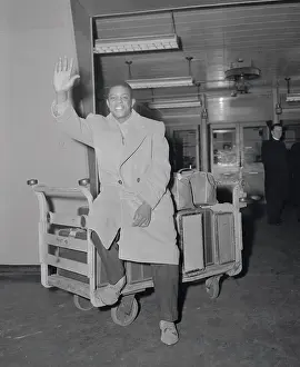 Willie Mays in Overcoat and Waving to Camera While in Airport