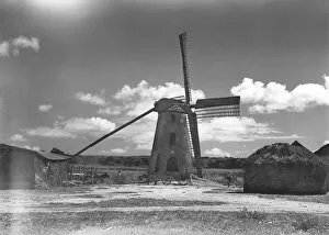 Windmill and haystack in field, (B&W)