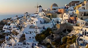 The windmills of Santorini in Greece. A hilltop town of whitewashed houses. Sunset