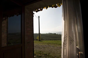 A window looking out to morning hill landscape of Val d Orcia