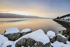 Images Dated 20th December 2012: Winter atmosphere at sunrise on the fjord, snow-covered rocks, coastal road, near Alesund, Norway