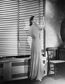 Using Phone Prints: Woman adjusting widow blind, (B&W)