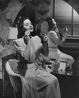 Woman applying make up at vanity table (B&W)