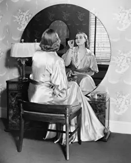 Blonde Hair Prints: Woman applying make up in front of vanity table, (B&W)