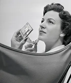 Cosmetics Prints: Woman Applying Makeup with a Compact