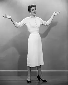 1960s Fashion Collection: Woman with arms raised in studio, portrait