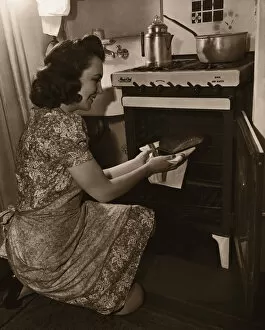 Woman baking bread in kitchen (B&W sepia tone)