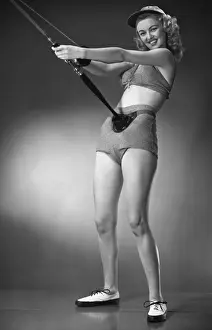 Woman in beachwear holding fishing rod