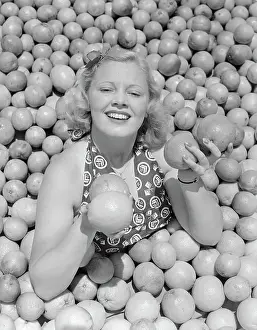 Pomona Prints: Woman Buried in Pile of Oranges