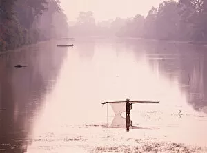 Images Dated 12th March 2013: Woman carrying fishing net across river