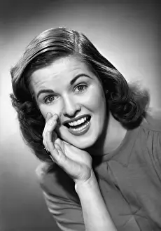 Wavy Hair Prints: Woman cupping hand at mouth in studio, (B&W), portrait