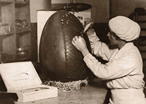 Images Dated 6th March 2015: Woman Decorating Fifteen Pound Chocolate Easter egg (B&W sepia)