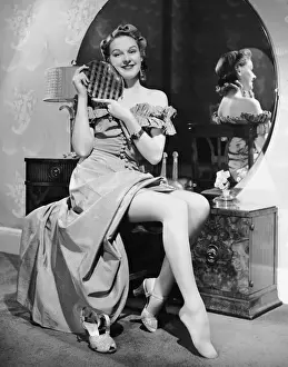 Woman at dressing table holding mirror