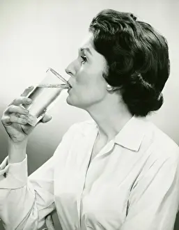 Earring Prints: Woman drinking water, posing in studio, (B&W), (Portrait)