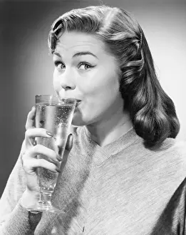 Raised Eyebrow Prints: Woman drinking water is studio, (B&W)