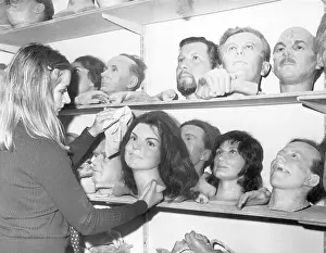 Woman Dusting Famous Heads in Waxworks Storage