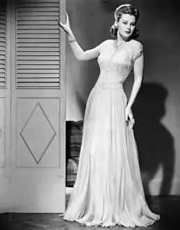 Woman in evening dress posing next to door