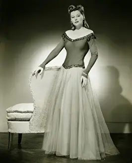 Raising Prints: Woman in evening dress standing indoors, (B&W)