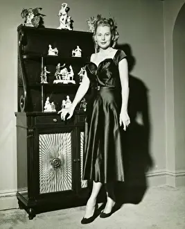 1950s Style Prints: Woman in evening gown posing at cabinet, (B&W), (Portrait)