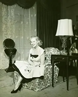 Black Colour Prints: Woman in fashionable dress sitting on armchair in living room, (B&W), portrait