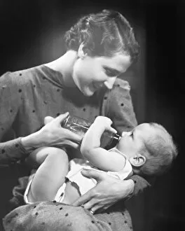 Support Collection: Woman feeding baby (6-9 months) in studio (B&W)
