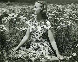 Exterior Space Prints: Woman in flowery dress sitting in meadow among flowers, (B&W), portrait