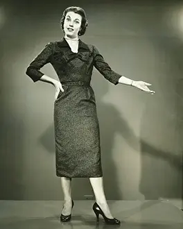 Woman gesturing in studio, (B&W), portrait