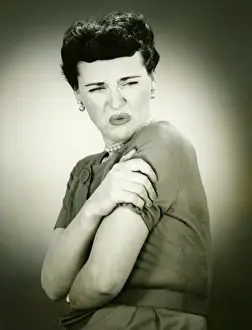 Woman grimacing, arms folded, (B&W), portrait