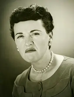 One Mid Adult Woman Only Prints: Woman grimacing in studio, (B&W), close-up, portrait