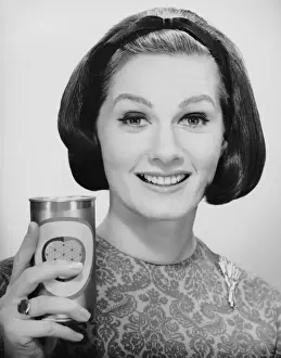 Woman holding up can of beer