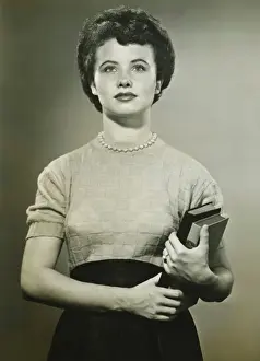 Looking Away Prints: Woman holding books, posing in studio, (Portrait), (B&W)