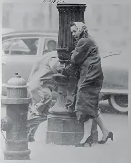 Woman Holding onto Lamp Post